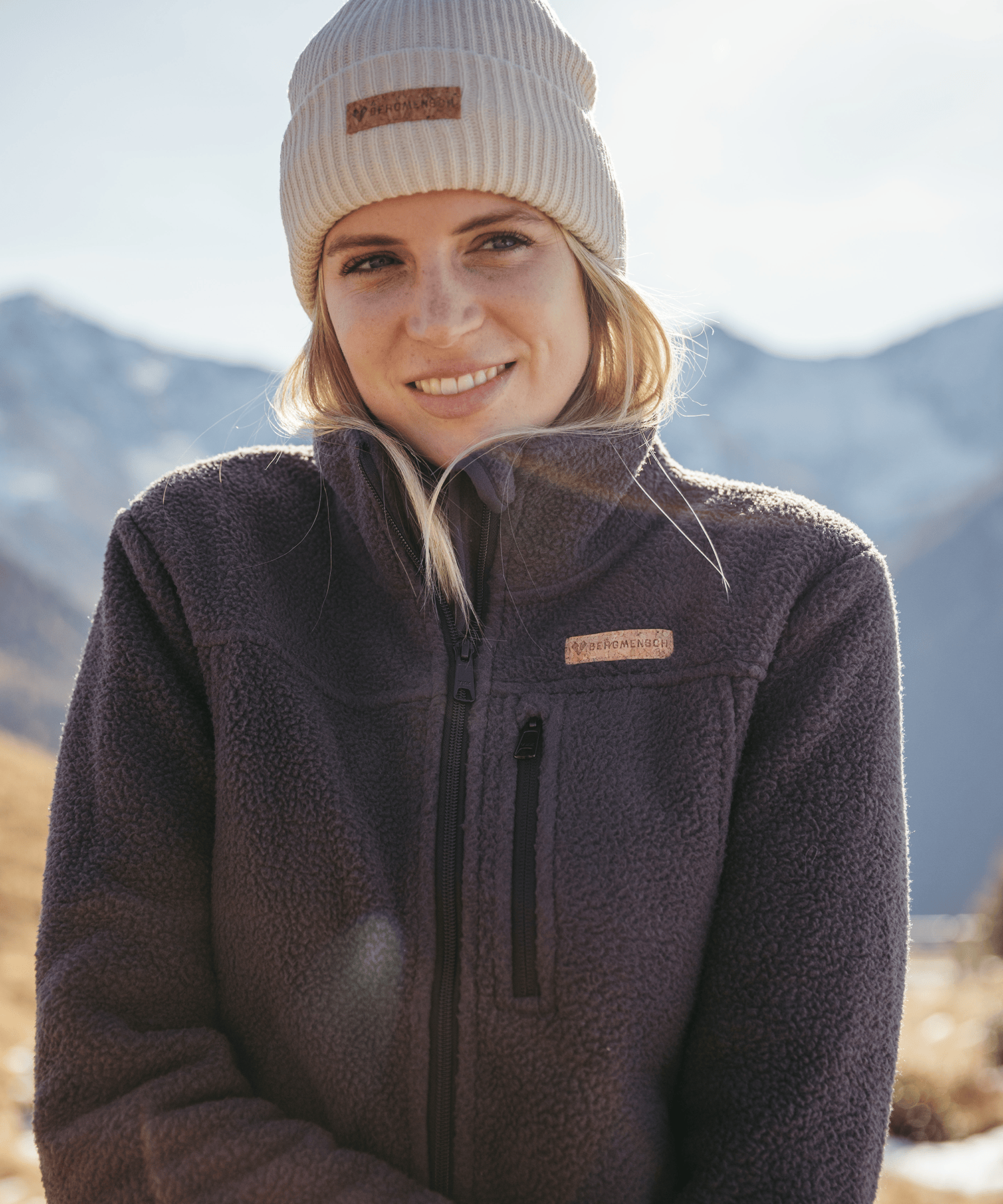 Model trägt die BERGMENSCH Damen Sherpa Fleece Jacke in der Farbe Ink Black und die Cozy Fleece Beanie in der Farbe Whitecap Grey