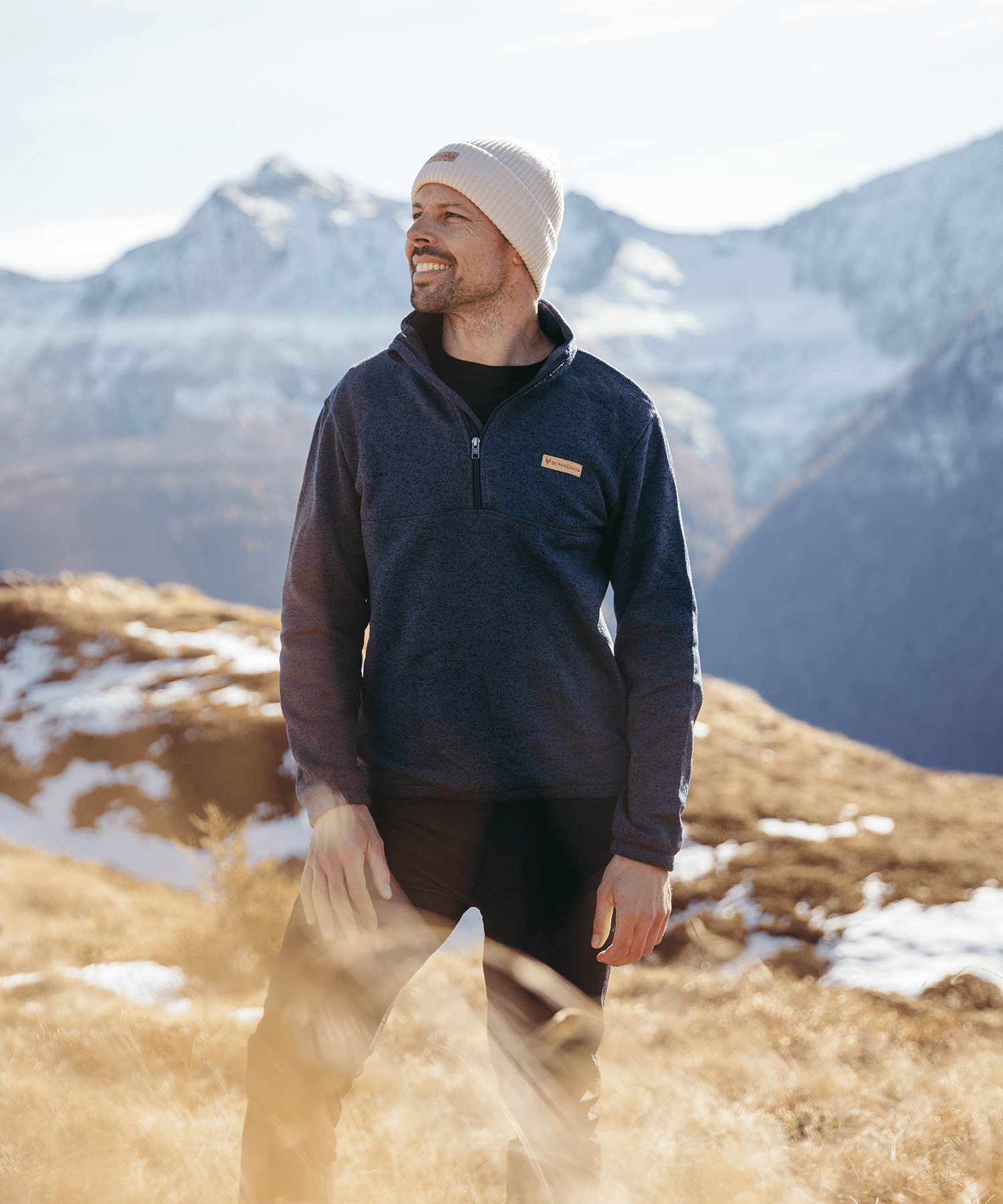 Model trägt den BERGMENSCH Herren Half-zip Strickfleece in Navy in den Bergen