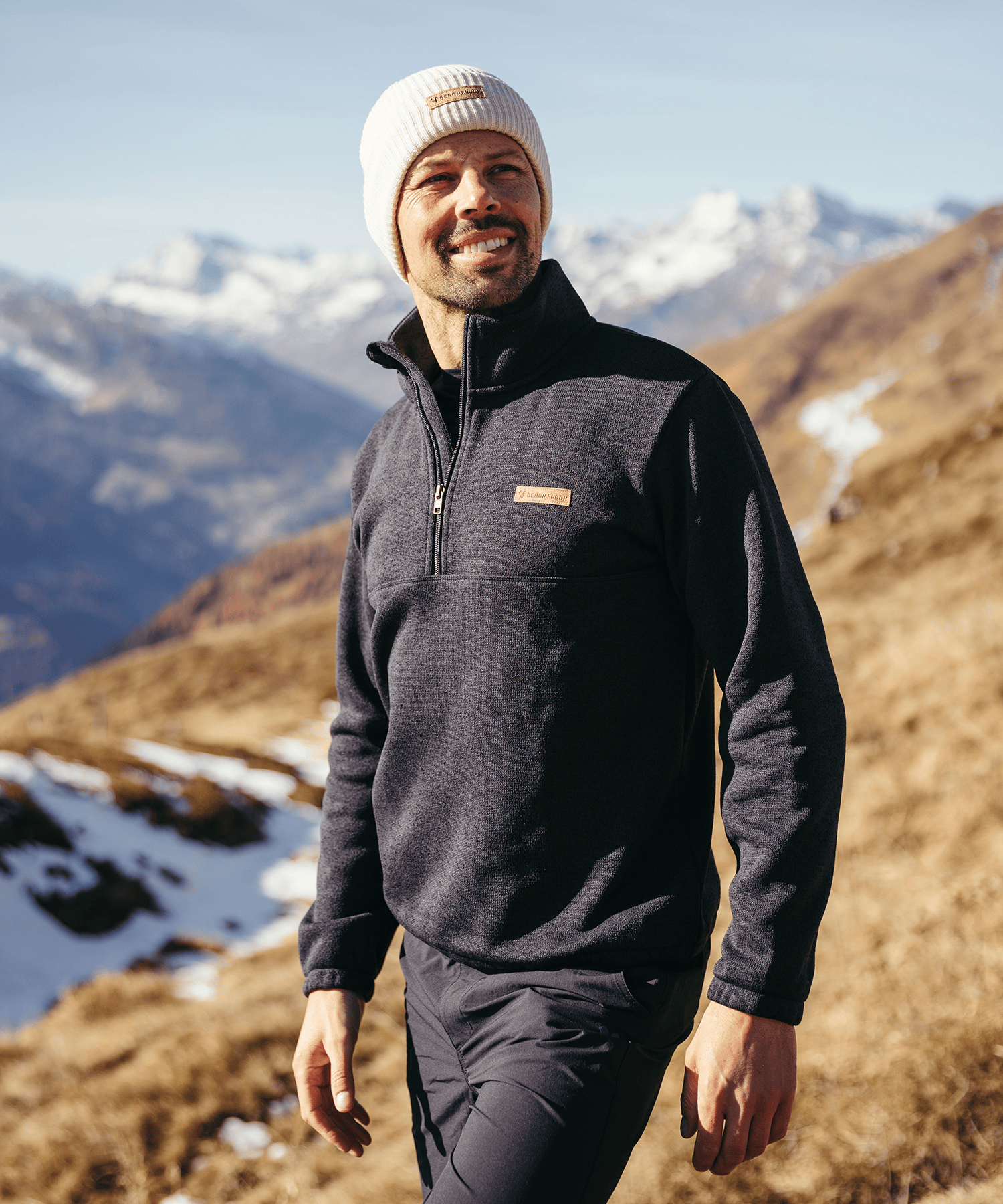 Model trägt den BERGMENSCH Herren Half-zip Strickfleece in Schwarz in den Bergen