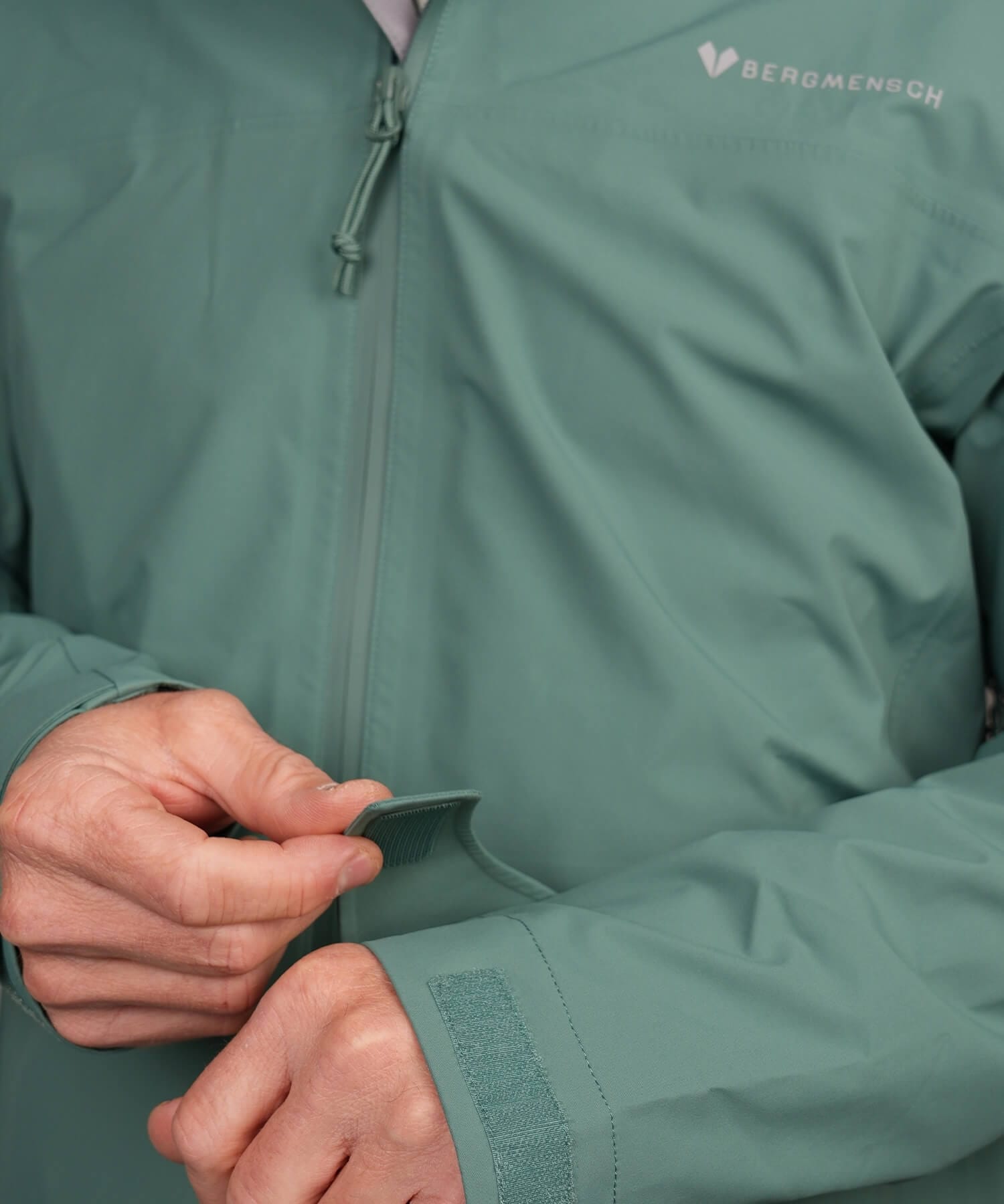 Detailansicht Ärmelabschluss mit Klettverschluss der BERGMENSCH Herren 3-Lagen Regenjacke in der Farbe Deep Lake